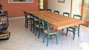 Table rustique XL en épicéa thermo-brossé avec piètement en X et deux rallonges, fabriquée sur mesure par Mont Copeaux et livrée à Annecy.